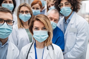 Group of doctors with face masks looking at camera, corona virus concept
