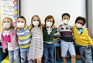 Kindergarten kids wearing masks in a classroom