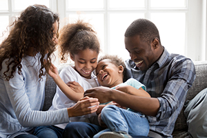 Smiling black family have fun at home with little kids