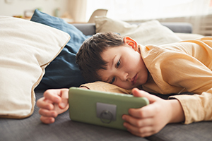 bored boy playing on phone