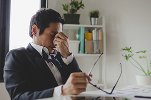 businessman rubbing eyes