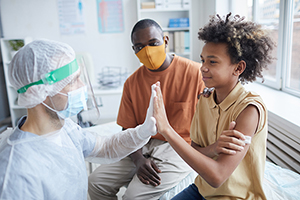 child at doctors with hands up