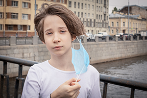 child taking mask off