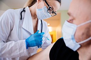 female doctor giving vaccine to man