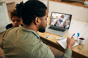 man holding son and video chatting