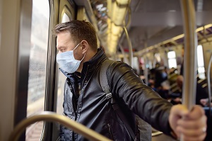 man wearing disposable medical face mask in car of the subway