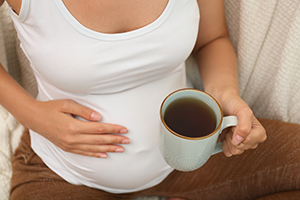 Pregnant person drinking tea