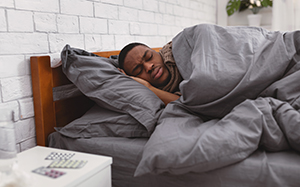 sick man sleeping in bed