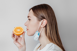 woman smelling orange