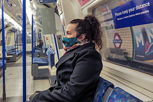 woman with mask sitting on train